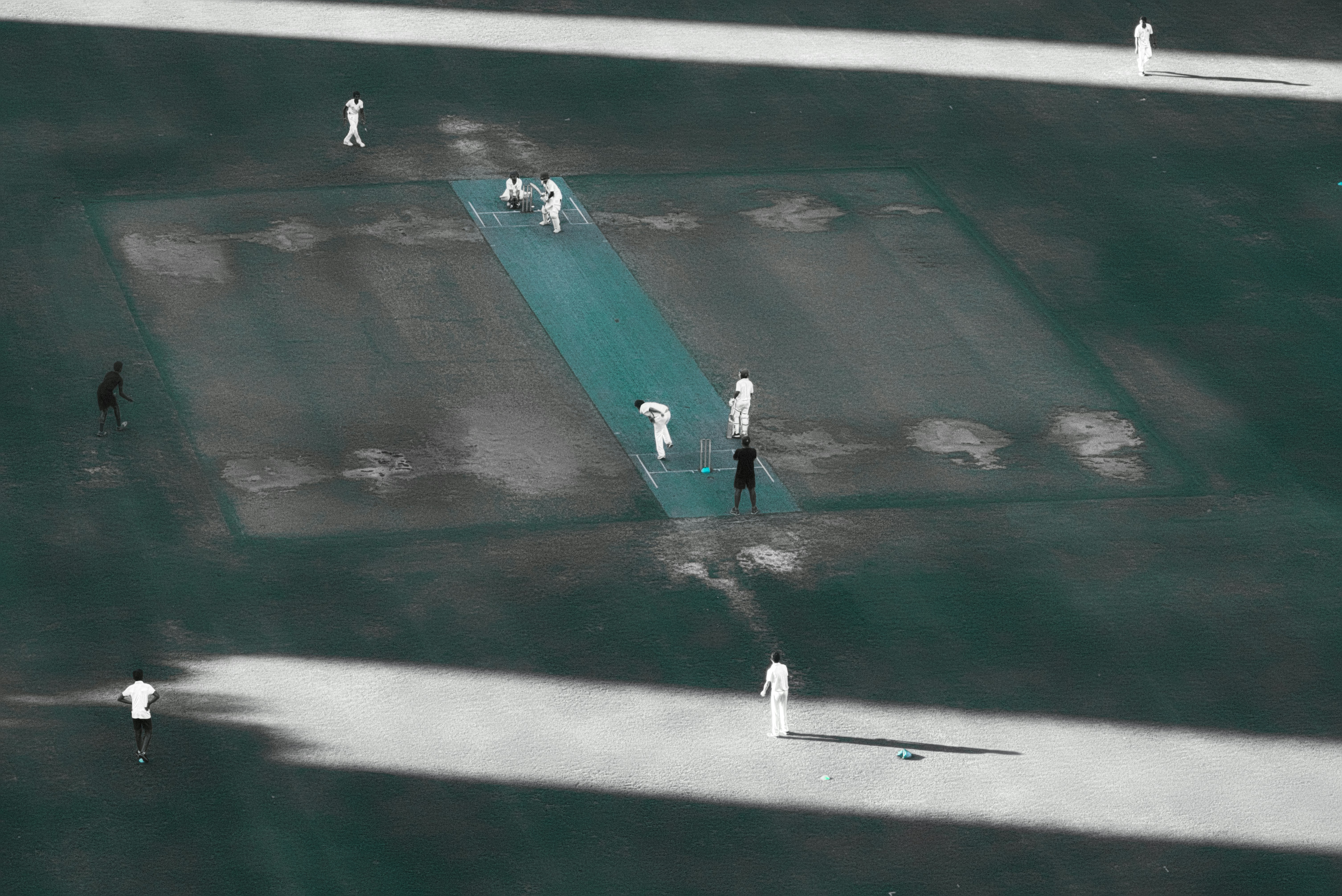people playing cricket game on field